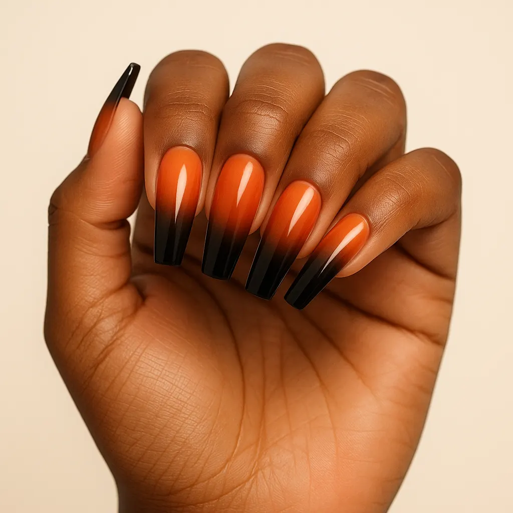 Long coffin nails fading from bright orange at the cuticle to black at the tip, on morena skin.
